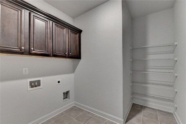 washroom with hookup for a washing machine, cabinets, light tile patterned floors, and hookup for an electric dryer