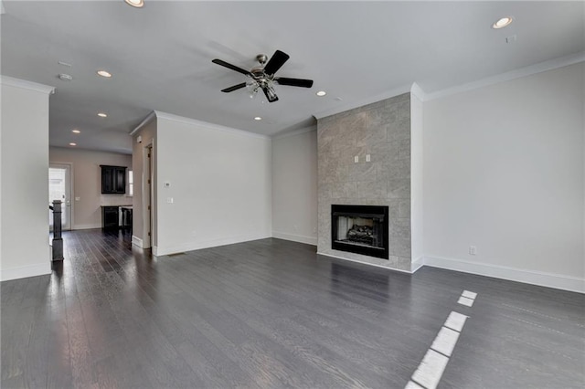 unfurnished living room with dark wood-type flooring, ceiling fan, crown molding, and a tile fireplace