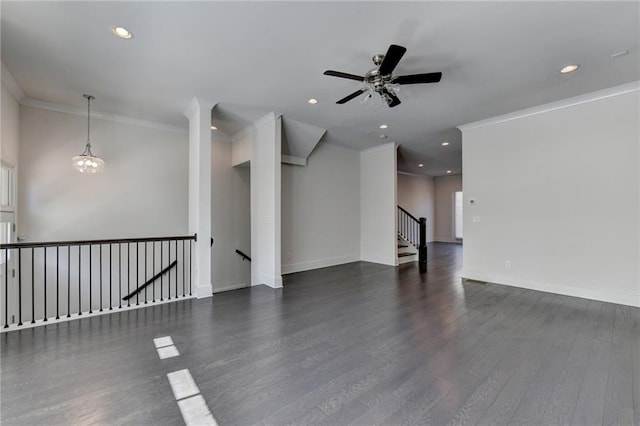 spare room with ornamental molding, dark hardwood / wood-style floors, and ceiling fan with notable chandelier