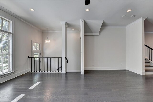 spare room with a notable chandelier, crown molding, and dark hardwood / wood-style flooring