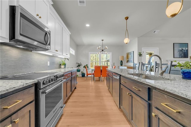 kitchen featuring sink, white cabinets, stainless steel appliances, and dark brown cabinets