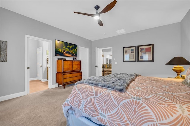 bedroom with ensuite bathroom, ceiling fan, and light carpet