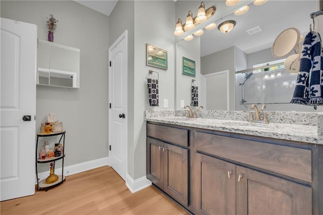 bathroom featuring hardwood / wood-style floors, vanity, and walk in shower