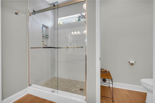 bathroom featuring hardwood / wood-style flooring, toilet, and walk in shower