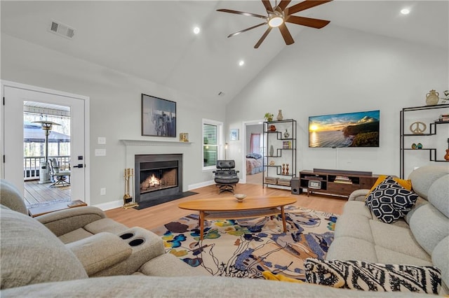 living room featuring hardwood / wood-style floors, ceiling fan, and high vaulted ceiling