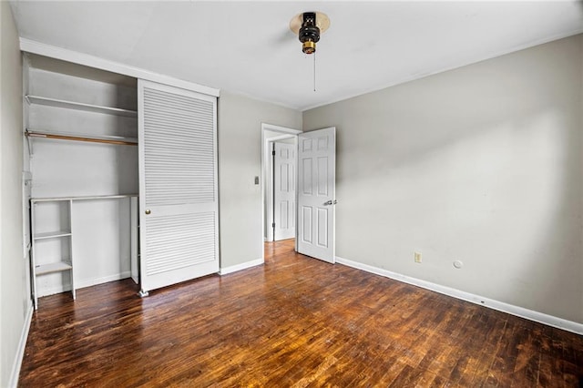 unfurnished bedroom featuring dark wood-type flooring and a closet