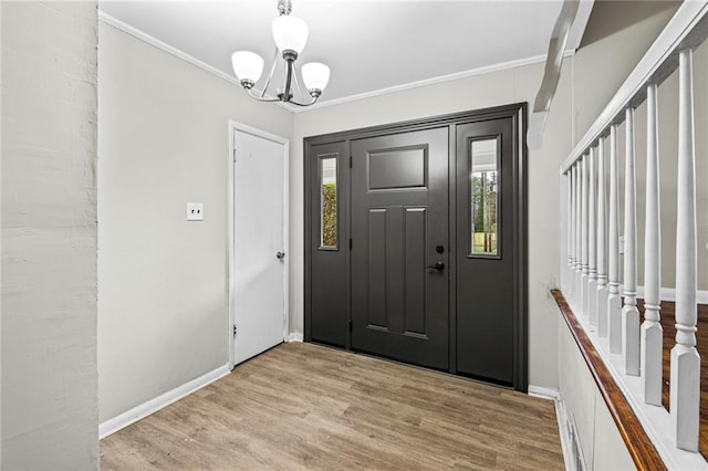 foyer featuring a chandelier, crown molding, and light hardwood / wood-style flooring