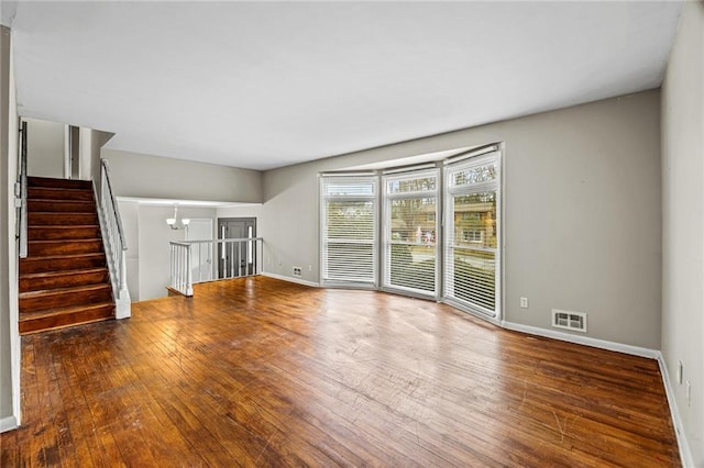 unfurnished living room with hardwood / wood-style flooring and an inviting chandelier