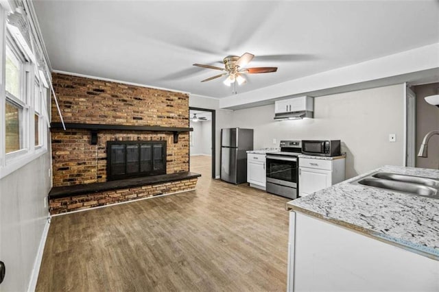 kitchen featuring white cabinets, sink, ceiling fan, appliances with stainless steel finishes, and light hardwood / wood-style floors