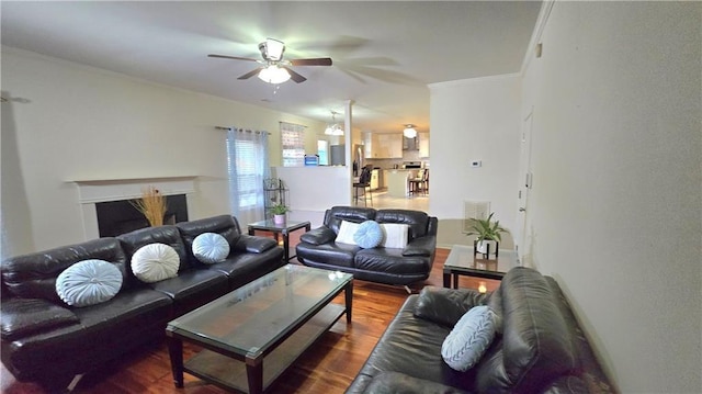 living room featuring hardwood / wood-style flooring, ornamental molding, and ceiling fan