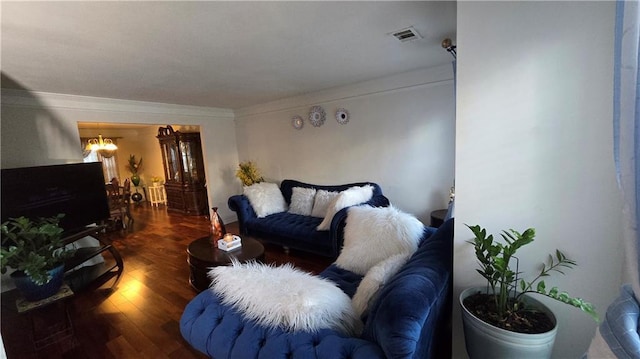 living room featuring crown molding, dark wood-type flooring, and a chandelier