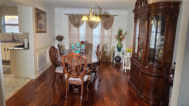 dining room featuring dark hardwood / wood-style flooring, sink, crown molding, and a chandelier