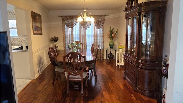 dining space featuring ornamental molding, dark hardwood / wood-style floors, and an inviting chandelier