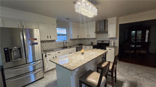 kitchen featuring sink, appliances with stainless steel finishes, a kitchen island, decorative light fixtures, and wall chimney exhaust hood