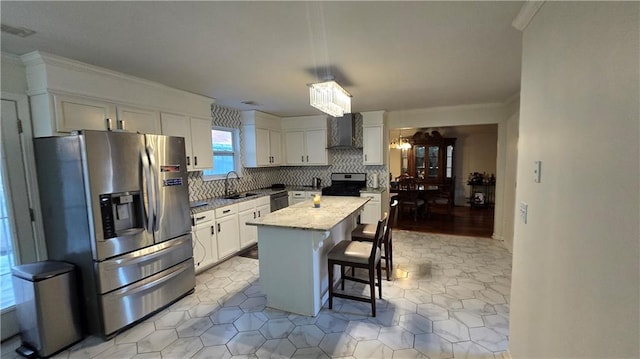 kitchen featuring wall chimney exhaust hood, a breakfast bar, white cabinetry, appliances with stainless steel finishes, and a kitchen island