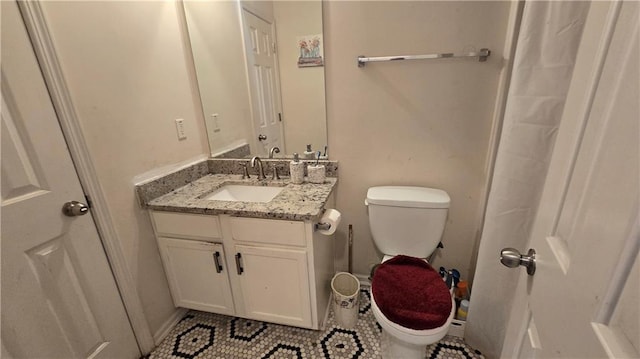 bathroom featuring vanity, tile patterned floors, and toilet