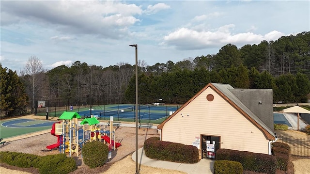 exterior space featuring basketball hoop, tennis court, and a playground