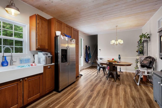 kitchen with brown cabinetry, an inviting chandelier, wood finished floors, stainless steel fridge, and wood ceiling