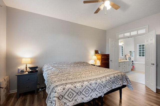 bedroom featuring baseboards, ceiling fan, wood finished floors, and ensuite bathroom