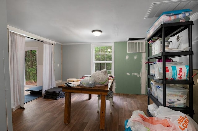office with visible vents, a wall unit AC, and wood finished floors