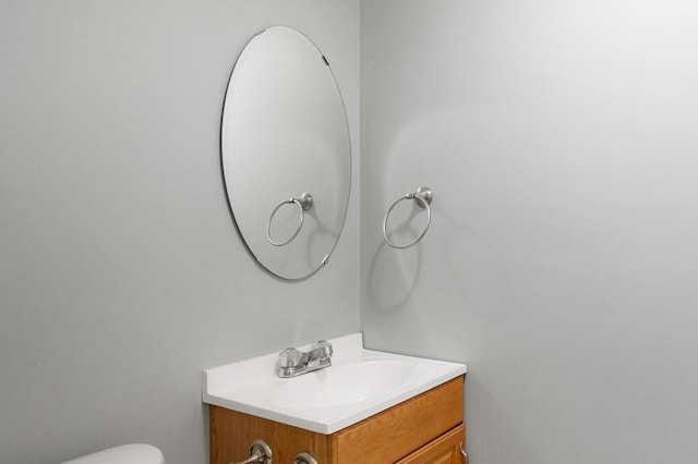 half bathroom featuring vanity and toilet