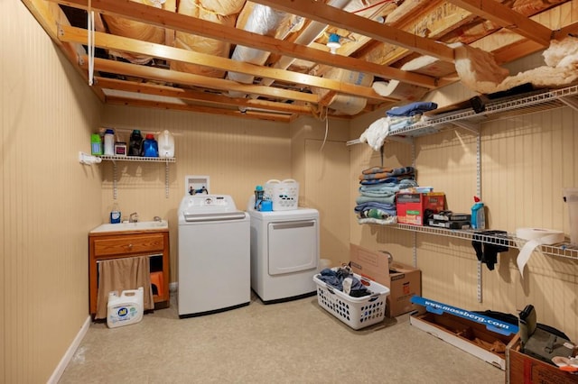 clothes washing area with laundry area, a sink, and washer and dryer
