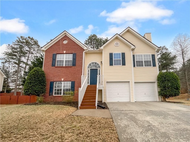 bi-level home with an attached garage, brick siding, fence, concrete driveway, and a chimney