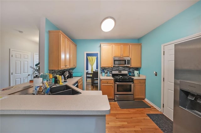 4321 Clairesbrook Ln, Acworth, GA 30101 - kitchen with stainless steel appliances, decorative backsplash, light brown cabinetry, light wood-type flooring, and light countertops