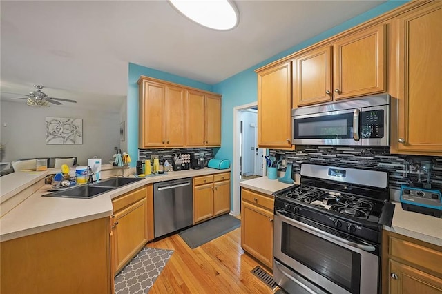 4321 Clairesbrook Ln, Acworth, GA 30101 - kitchen featuring appliances with stainless steel finishes, light wood finished floors, tasteful backsplash, a peninsula, and a ceiling fan
