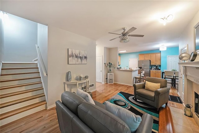 4321 Clairesbrook Ln, Acworth, GA 30101 - living room featuring light wood-style flooring, ceiling fan, stairs, and baseboards