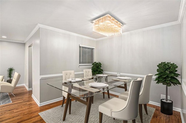 dining space featuring crown molding, dark hardwood / wood-style flooring, and a chandelier