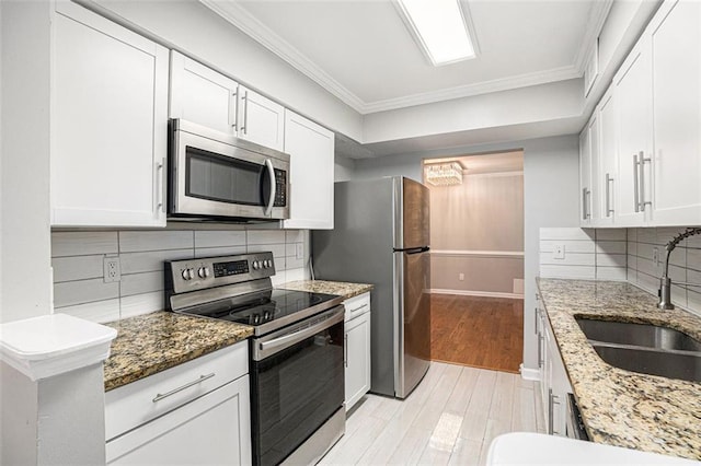 kitchen with stone counters, stainless steel appliances, sink, and white cabinets