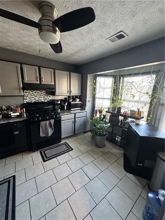 kitchen featuring ceiling fan, gray cabinetry, backsplash, black appliances, and light tile patterned flooring