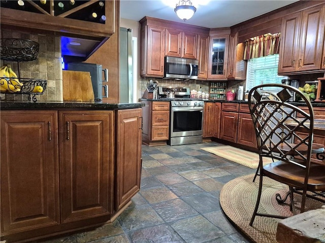 4094 Carlisle Pl, Stone Mountain, GA 30083 - kitchen with appliances with stainless steel finishes, backsplash, stone tile floors, and dark countertops