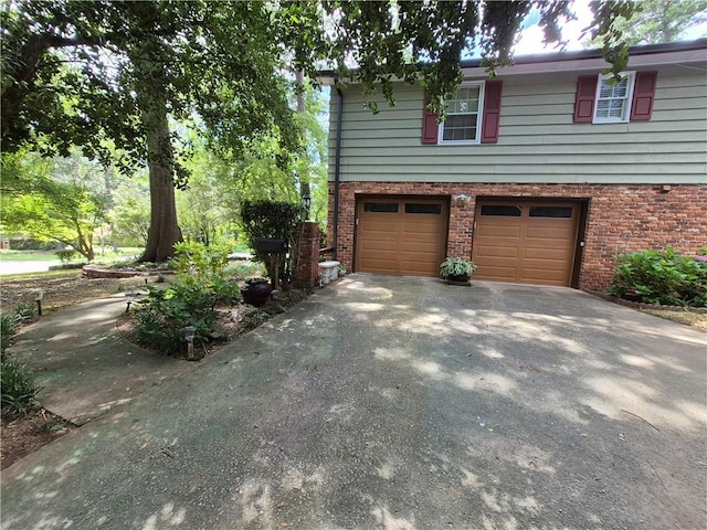 4094 Carlisle Pl, Stone Mountain, GA 30083 - view of property exterior featuring brick siding, an attached garage, and driveway