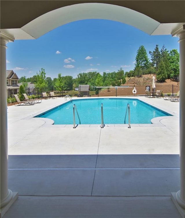 community pool featuring a patio and fence