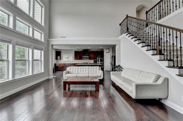 5770 Bridleton Xing, Suwanee, GA 30024 - living area with a high ceiling, dark wood finished floors, baseboards, and stairs