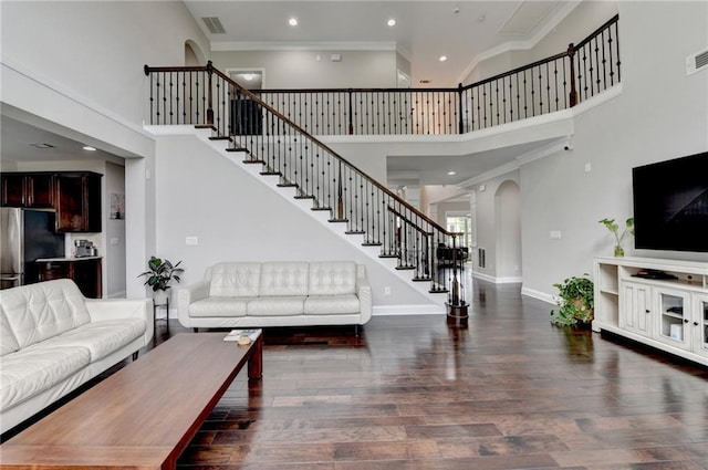 5770 Bridleton Xing, Suwanee, GA 30024 - living room featuring a towering ceiling, stairway, recessed lighting, baseboards, and arched walkways