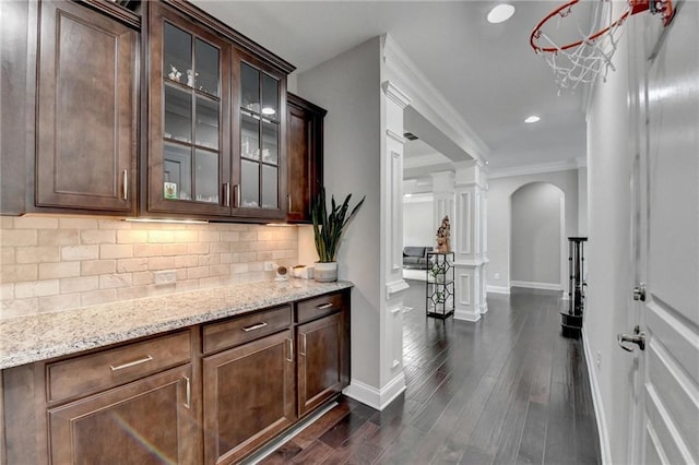 5770 Bridleton Xing, Suwanee, GA 30024 - bar area with arched walkways, decorative columns, tasteful backsplash, baseboards, and dark wood finished floors