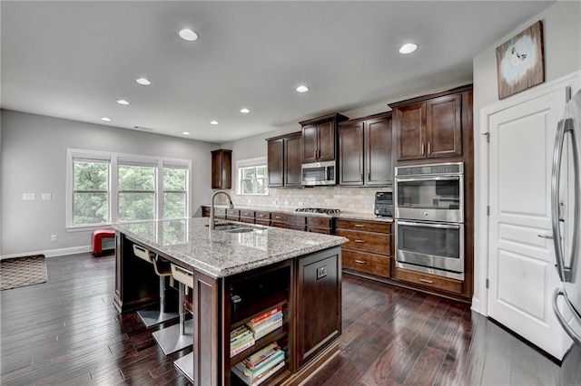 5770 Bridleton Xing, Suwanee, GA 30024 - kitchen with a sink, appliances with stainless steel finishes, dark wood finished floors, decorative backsplash, and recessed lighting