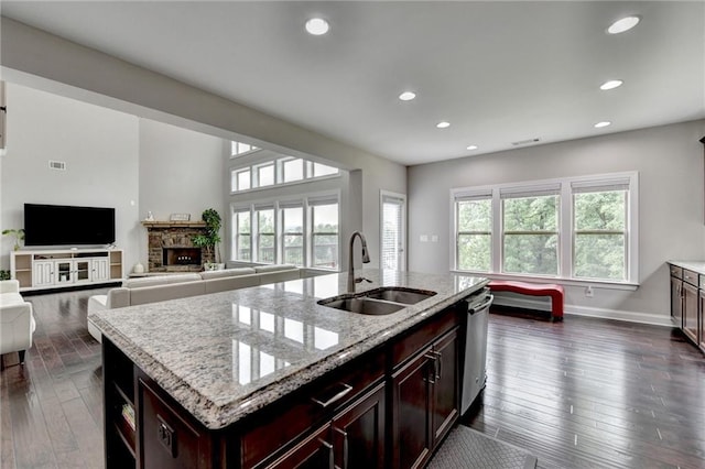 5770 Bridleton Xing, Suwanee, GA 30024 - kitchen featuring a sink, a stone fireplace, stainless steel dishwasher, dark wood finished floors, and recessed lighting