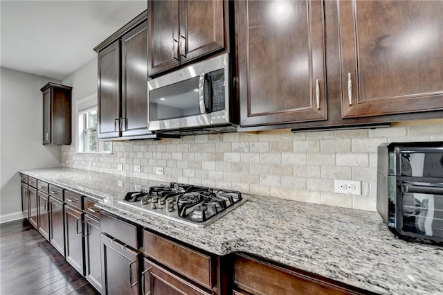 5770 Bridleton Xing, Suwanee, GA 30024 - kitchen with stainless steel appliances, dark wood-type flooring, light stone countertops, baseboards, and dark brown cabinets
