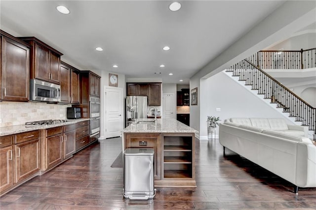 5770 Bridleton Xing, Suwanee, GA 30024 - kitchen featuring appliances with stainless steel finishes, open floor plan, recessed lighting, dark wood-style flooring, and a sink