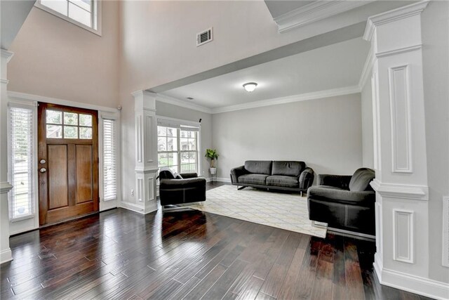 5770 Bridleton Xing, Suwanee, GA 30024 - foyer featuring ornate columns, dark wood-type flooring, crown molding, baseboards, and a towering ceiling