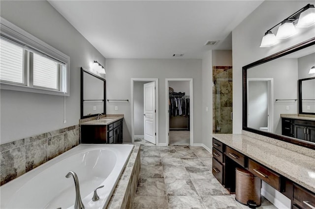 5770 Bridleton Xing, Suwanee, GA 30024 - bathroom featuring a shower stall, a bath, vanity, and a spacious closet