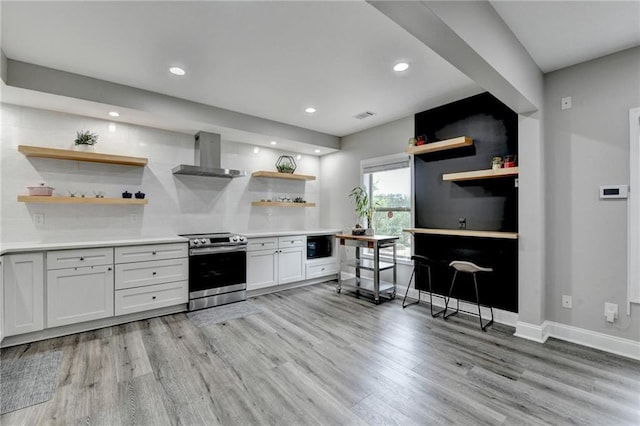 5770 Bridleton Xing, Suwanee, GA 30024 - kitchen featuring electric stove, open shelves, wall chimney range hood, light wood-style flooring, and light countertops