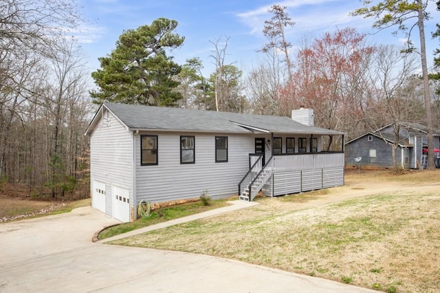 ranch-style house with a chimney, stairway, an attached garage, driveway, and a front lawn