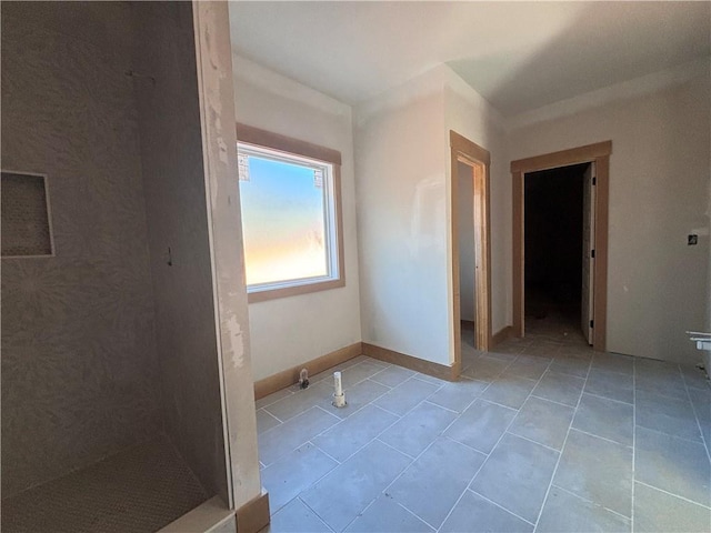 tiled empty room featuring baseboards