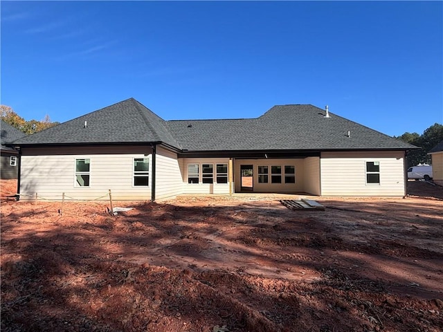 back of property featuring a patio and a shingled roof