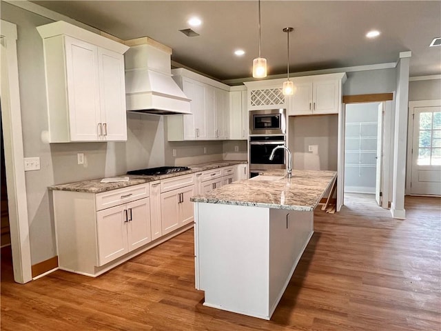 kitchen featuring white cabinets, custom range hood, and stainless steel appliances